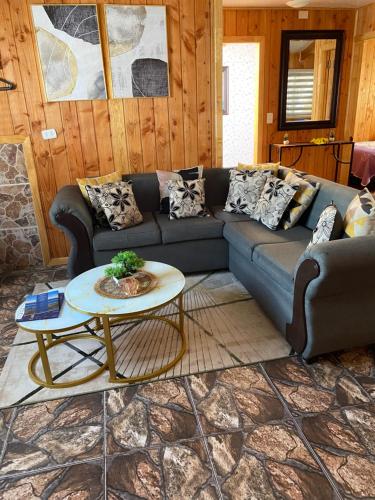 a living room with a couch and a table at Cabaña jazmin in Chaitén