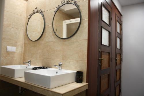 a bathroom with two sinks and two mirrors on the wall at Alegria Rooms in Porto