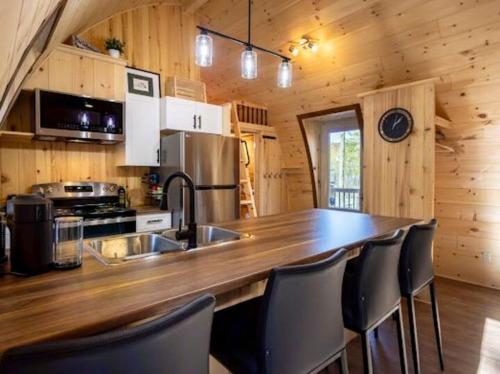 a kitchen with a large wooden counter top in a cabin at Le POD du Mont ADSTOCK spa golf ski plein air arcade in Adstock