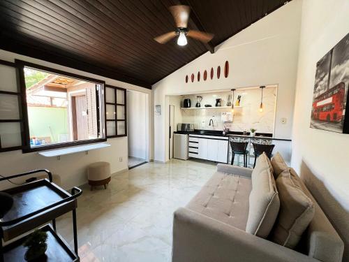Casa aconchegante a 7 min da Praia في بوزيوس: غرفة معيشة مع أريكة ومطبخ