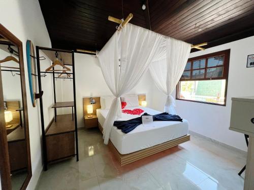 Casa aconchegante a 7 min da Praia في بوزيوس: غرفة نوم بسرير مع ناموسية