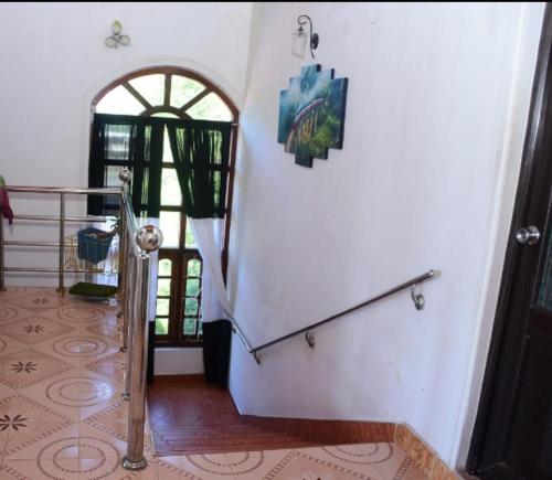 a staircase in a house with a door and a stair case at The bawa guest Inn in Haputale