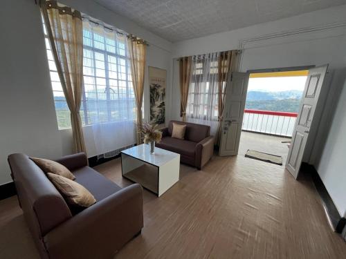 a living room with two couches and a table at PuVi Homestay, Dzukou entry point in Viswema