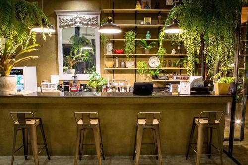 a bar in a restaurant with three stools at Phingphayla Photharam in Ratchaburi