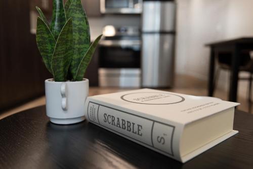 a book sitting on a table next to a potted plant at Luxury Apartment in Downtown SLC in Salt Lake City