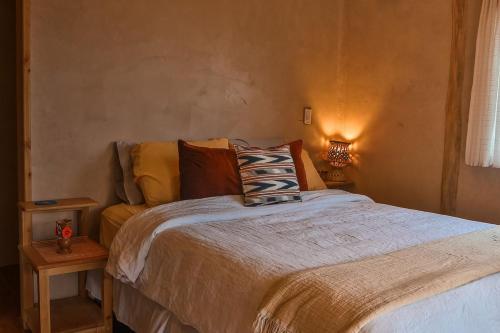 a bedroom with a bed with a pillow on it at Casa Awänímä - Luxury Permaculture Hotel & Eco-Retreat in Tzununá