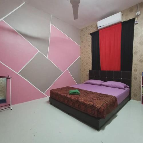 a bedroom with a bed with pink and red walls at Kak Chik Homestay Kepala Batas in Kepala Batas