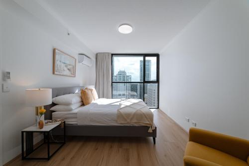 Un dormitorio blanco con una cama y una ventana. en Lux 39th floor 2br 2bath, River view, Pool, Gym, Wifi, en Brisbane