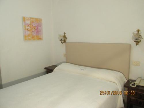 a bedroom with a white bed and a painting on the wall at Hotel Conde in Taboadela