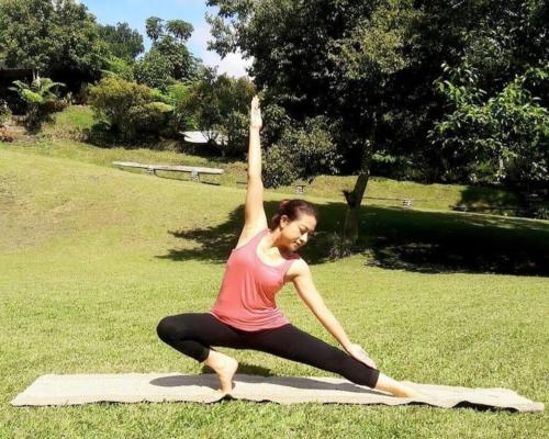 a woman doing yoga on a blanket in a park at Warung Rekreasi Bedugul in Bedugul