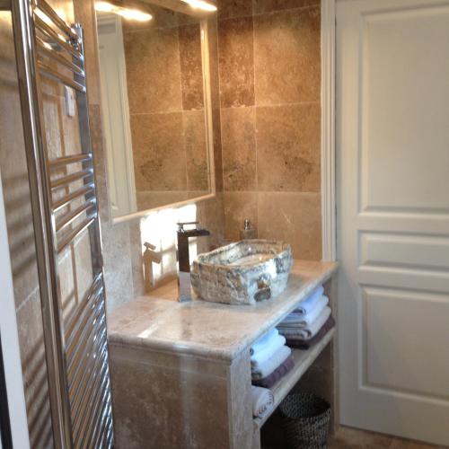 une salle de bain avec un lavabo en pierre et un miroir dans l'établissement Villa Prétorina, à Cannes