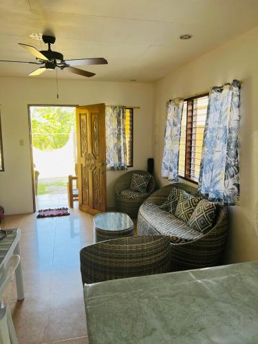 a living room with two couches and a ceiling fan at GJES Lodge AND GUESTHOUSE in Moalboal