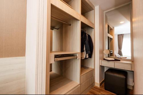 a walk in closet with wooden shelves and a desk at Stay with Pano at The Prio Condo in Chiang Mai