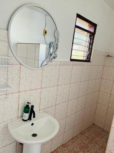 a bathroom with a sink and a mirror at GJES Lodge AND GUESTHOUSE in Moalboal
