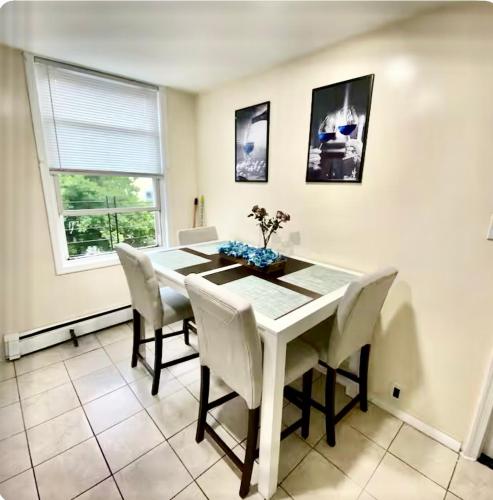 a dining room with a white table and chairs at Private Room A-KING BED-12Mints NYCity in West New York