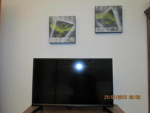 - une télévision à écran plat dans une chambre avec trois photos dans l'établissement Hotel Conde, à Taboadela