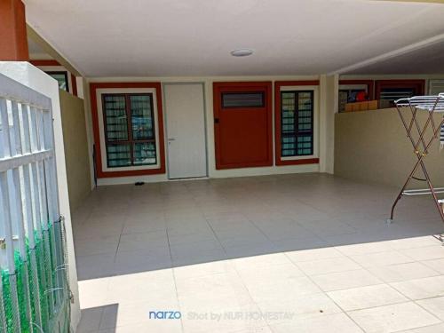 an empty room with a red door in a house at Nur Homestay bersih dan tenang in Kampong Piangu