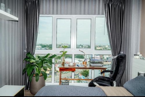 a room with a desk and a large window at Stay with Pano at The Prio Condo in Chiang Mai