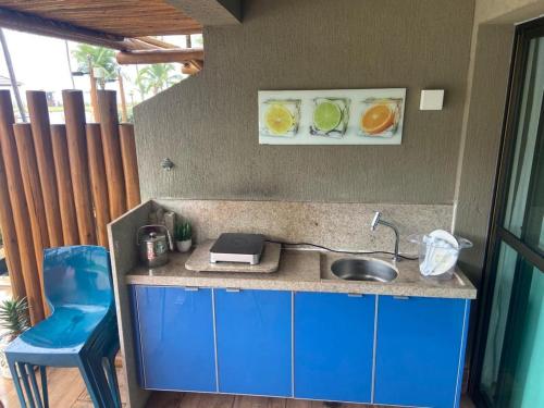 a small kitchen with a sink and a blue chair at Refeições inclusa - Polinesia Resort - Porto de Galinhas - Apartamentos com somente 1 opção de Térreo com Piscina Privativa - Acesso ao Hotel Samoa in Porto De Galinhas