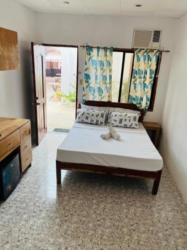 a bedroom with a bed with a bow on it at GJES Lodge AND GUESTHOUSE in Moalboal