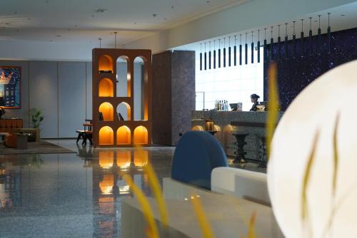 a lobby of a hotel with a table and chairs at Arthur Hotel Liwan COCO Park Dongsha Metro Guangzhou-24H Coffee & Low Tea & Free Shuttle Bus For Canton Fair By Paco in Guangzhou