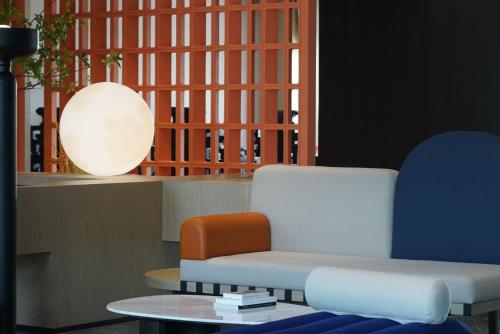 a living room with a chair and a table at Arthur Hotel Liwan COCO Park Dongsha Metro Guangzhou-24H Coffee & Low Tea & Free Shuttle Bus For Canton Fair By Paco in Guangzhou