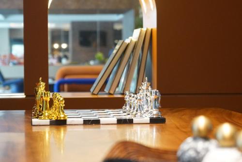 a chess board with miniature figurines on a table at Arthur Hotel Liwan COCO Park Dongsha Metro Guangzhou-24H Coffee & Low Tea & Free Shuttle Bus For Canton Fair By Paco in Guangzhou