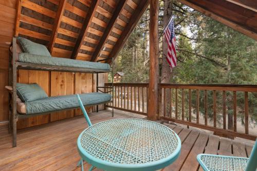 a porch with a table and chairs on a deck at The Knotty Cabin in Kings Canyon National Park in Wilsonia
