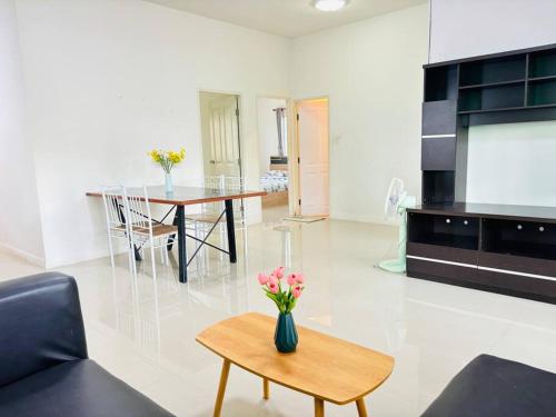 a living room with a vase of flowers on a table at บ้านม่วนใจ๋ดีญ่า in Ban Pa Lan