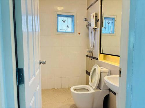 a bathroom with a toilet and a sink at บ้านม่วนใจ๋ดีญ่า in Ban Pa Lan