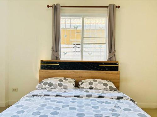 a bedroom with a bed with a large window at บ้านม่วนใจ๋ดีญ่า in Ban Pa Lan