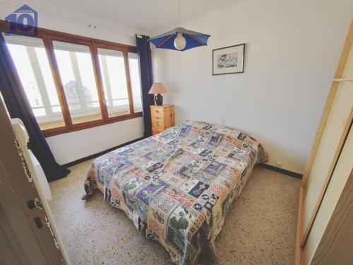 une chambre avec un lit avec une couette dessus dans l'établissement Appartement 6 pers, accès plage, parking sécurisé - FR-1-781-69, à Valras-Plage