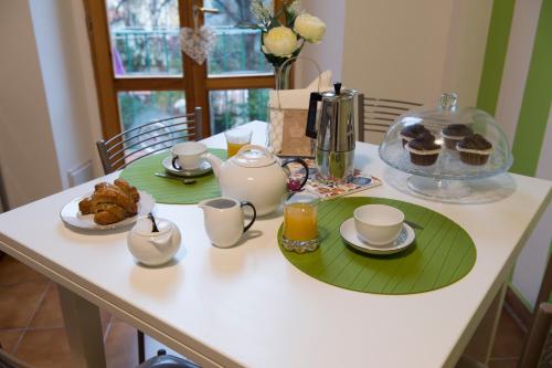 a table with tea and muffins and a tray of cupcakes at La Filarocca B&B in Florence