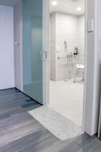 a bathroom with a shower and a glass door at Hu House in Kaohsiung