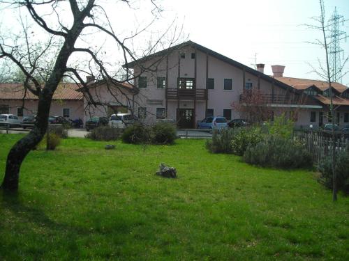 a house with a yard with a tree in the grass at Bajta Fattoria Carsica in Baita