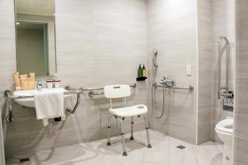 a bathroom with a shower and a toilet and a stool at Hu House in Kaohsiung