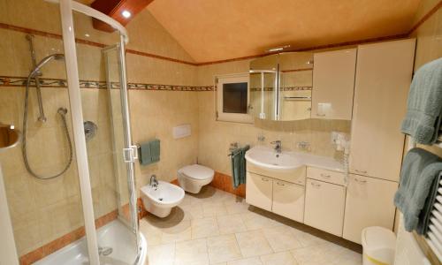 ein Badezimmer mit zwei Waschbecken, einer Dusche und einem WC in der Unterkunft Bruneggerhof in Weißenbach