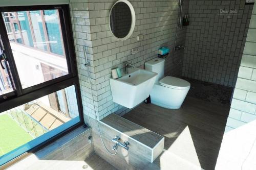 a bathroom with a toilet and a sink and a window at Wandao in Donggang