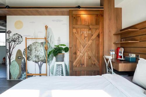 a bedroom with a white bed and a wooden door at Wandao in Donggang
