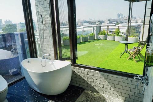 a bathroom with a tub and a view of a yard at Wandao in Donggang