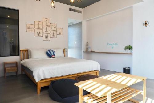 a bedroom with a bed and a bench in it at Wandao in Donggang