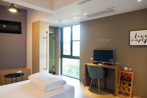 a bedroom with a bed and a desk with a computer at Wandao in Donggang