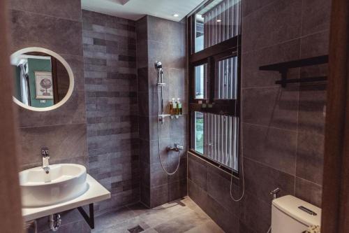 a bathroom with a sink and a toilet and a mirror at Wandao in Donggang