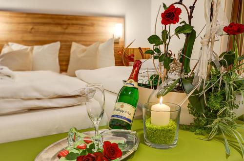 a green table with a bottle of champagne and a candle at Landhaus Bennstedt in Bennstedt