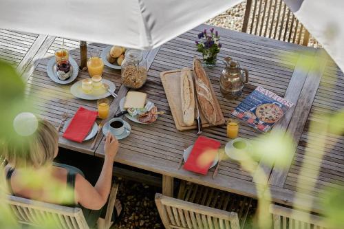 a woman sitting at a table with food and drinks at Abbaye du Palais in Thauron