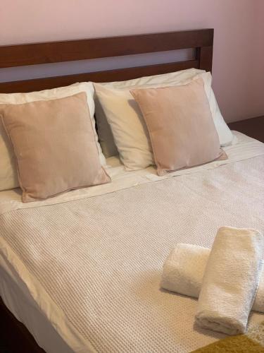 a bed with two pillows and two towels on it at double room in Auckland