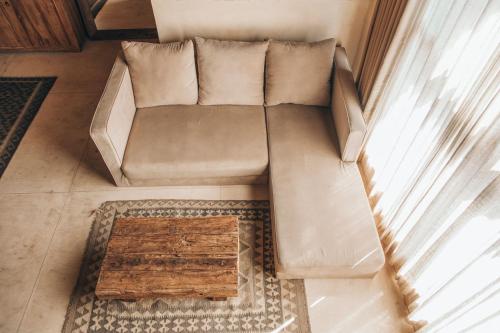 a couch sitting in a living room next to a window at Lulu's Villas in Uluwatu