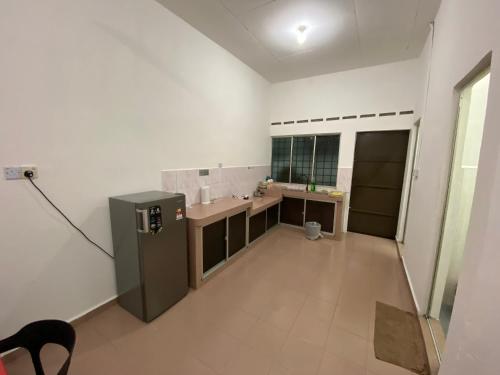 a large white kitchen with a sink and a refrigerator at Pagoh Town homestay 2 in Pagoh