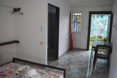 a bedroom with a bed and a table and a window at B&B Il Padrino in Puerto Jiménez