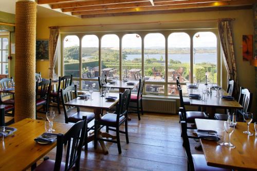 a restaurant with wooden tables and chairs and large windows at Casey's Of Baltimore Collection Caseys of Baltimore Hotel Baltimore Lodge Baltimore Cottage in Baltimore